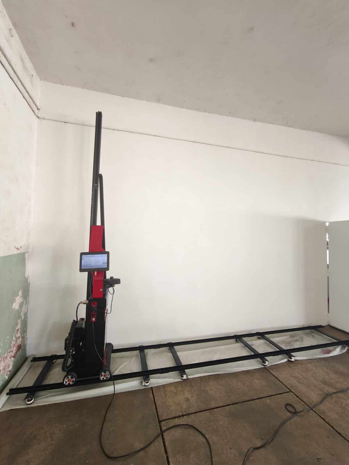 Mur en béton du préau de l'école avant l'impression de la fresque, imprimante murale installée sur ses rails