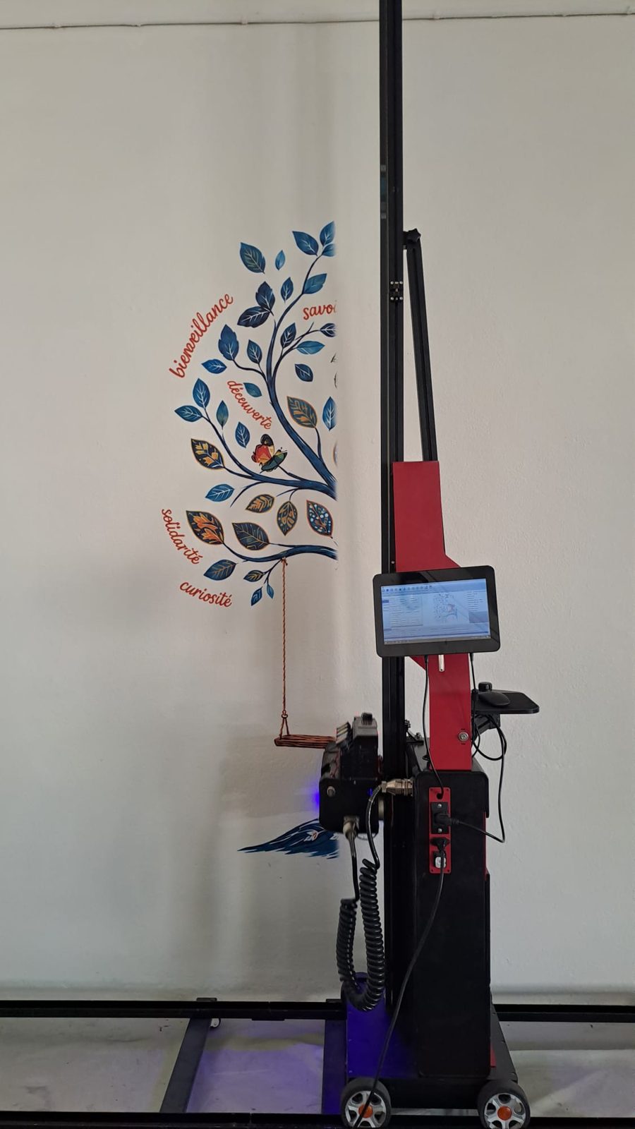 Fresque de l'école Sainte-Anne en cours d'impression, la moitié gauche de l'arbre est déjà imprimée sur le mur